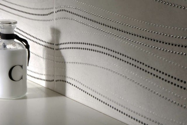 Vlnité pruhy vyrobené z trblietavých perlových dlaždíc v stene v kúpeľni