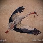 Az elvégzett gólya tetoválás egyedi változata - a rajz alkalmas egy gyermeket hordozó gólya tetoválására