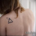 fénykép a halálos ereklyék tetoválásáról 180. sz. - a minta egyedi változata, amely sikeresen használható a halálos ereklyék feldolgozására és felhelyezésére a fül mögött tetoválásként