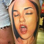 Tetovált portré fotója - egy lány arca, aki erotikusan kinyitotta a száját, és várakozással lehunyta a szemét