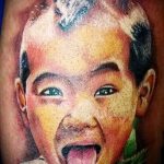 Fénykép a tetoválás portréja egy gyermek - ázsiai fiú mutatja a nyelvét