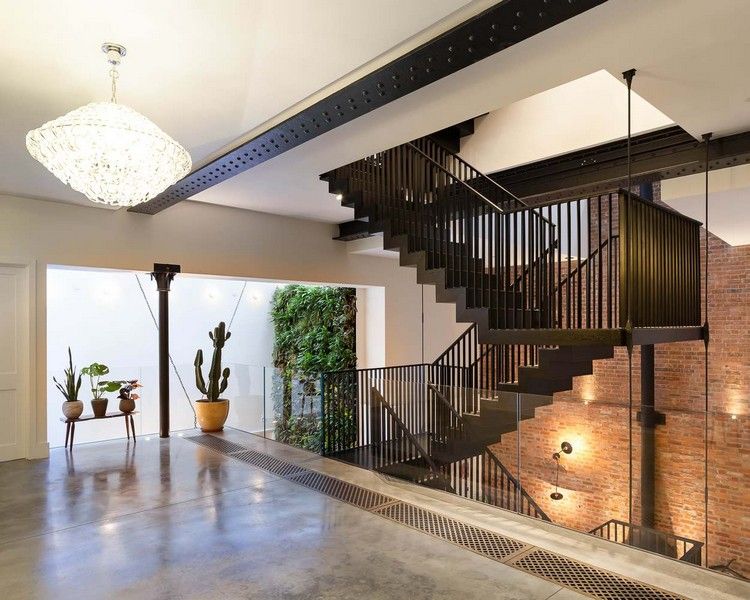 čierne schody drevo oceľové zábradlie tehlová stena priemyselná