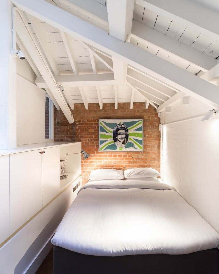 spálňa šikmá strecha biely trámový strop tehlová stena