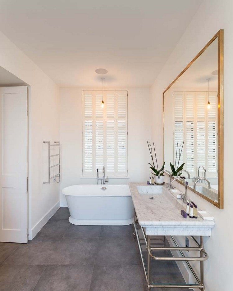 kúpeľňa šedá dlažba biela vaňa okno zrkadlo bronzový rám