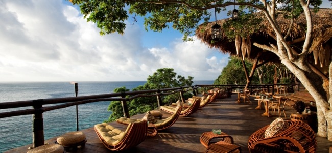 Drevené ležadlá z tkaného nábytku na terase Jedinečné kreslo v salóniku s drevenou palubou