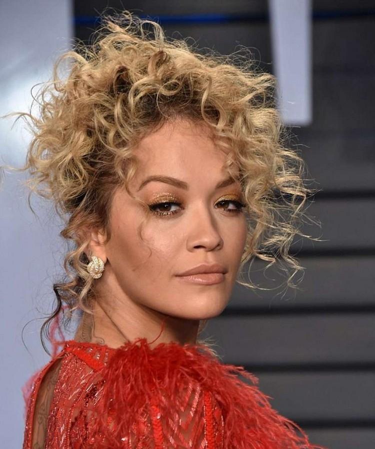 Účesy blond vlasov Rita Ora pre hranatú tvár a kučeravé vlasy