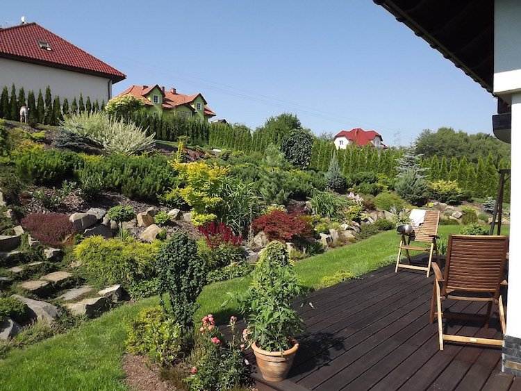 Terasa v zadnej záhrade s nádherným výhľadom na svah terénne úpravy-stráň -drevené palubovky-terasa-krík-skalka-trávnik