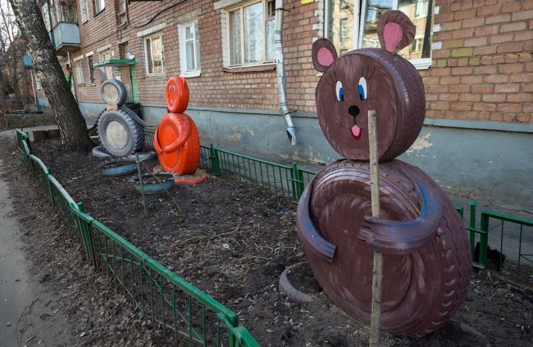 nápady na záhradu-so starými pneumatikami na auto, figúrkou z predného dvora, hnedou oranžovou