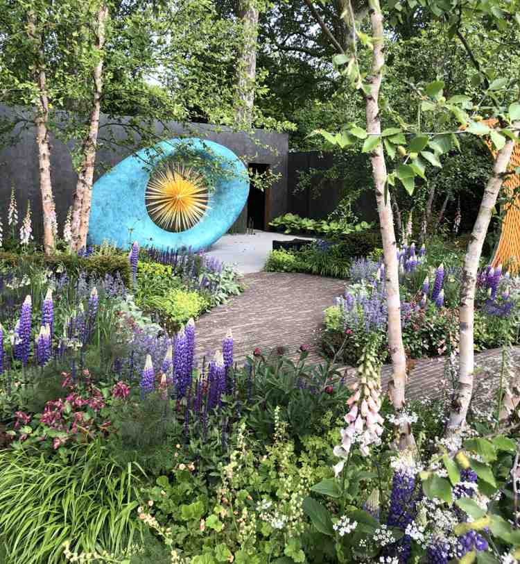 Lupiny purpurovo biele náprstky pod výsadbou stromov