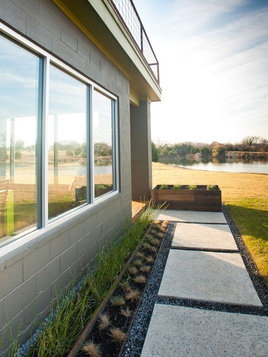 návrh prednej záhrady, ktorým sa ukladajú betónové dlaždice-vysoké črepníkové rastliny