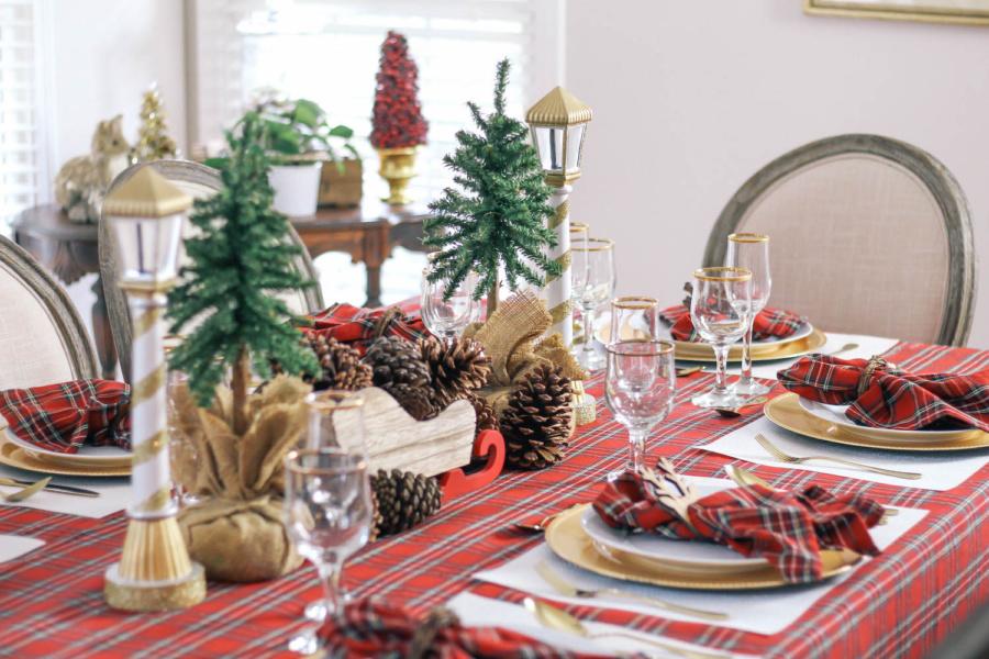 Dokonale prestretý vianočný stôl Nápady na klasické dekorácie na stôl s drevenými sánkami plnými šišiek a skutočných jedlí a lampášov a kontrolovaným držiakom na obrus a ting z vŕbových konárov