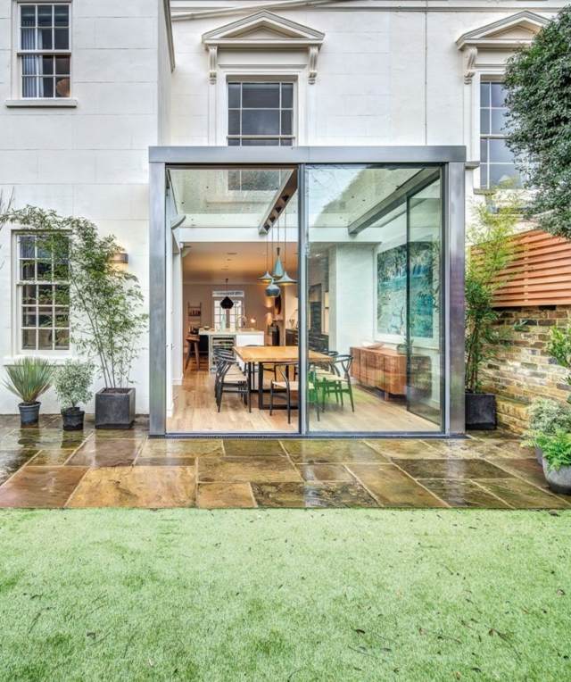 Bytový dom kultivácia sklenená stena kamenná dlažba trávnik Prístavba sklenená stena kamenná dlažba plocha trávnika stará budova