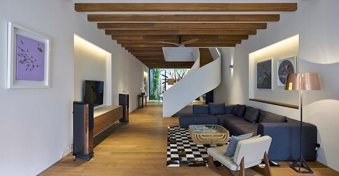 Trámový strop a točité schodisko s prízvukom bieleho zábradlia v obývacej časti moderne zariadená obývačka trámovým stropom točité schodisko-biele zábradlie