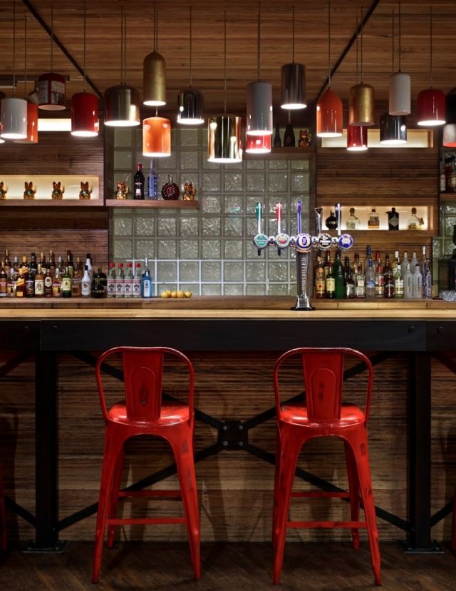 londýnsky hostel nový vzhľad červené kovové barové stoličky závesné svetlá londýnska oprava hostela červené kovové barové stoličky závesné svetlá