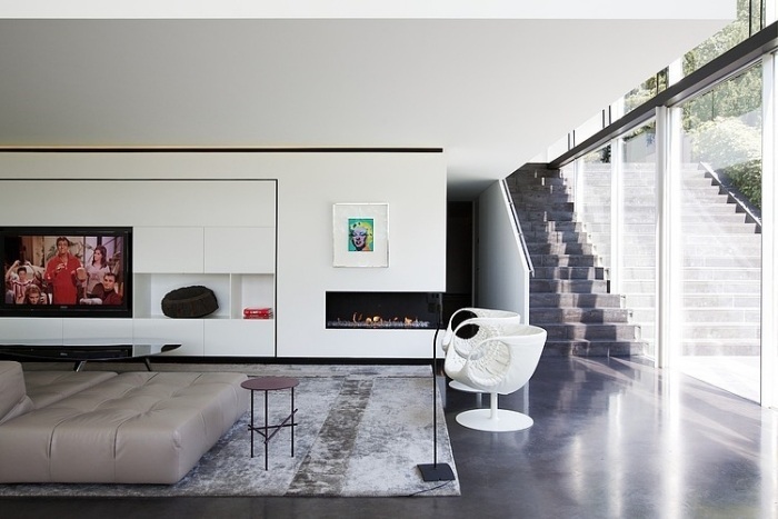 Puristická nástenná jednotka v bielej farbe so vstavanými policami a etanolovým krbom obývacia stena-biela-vstavaná-led-tv-etanol-krb-vinobranie-koberec-strop-vysoká-okenná stena