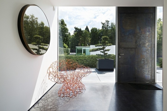 Konštrukcia chodby redukovaná na okrúhle nástenné zrkadlo a dizajnové kreslo z červeného drôtu architekti-dom-sklo-predná časť-interiérový dizajn-neobvyklé-dizajnérske kúsky-kreslo-vyrobené z drôtu