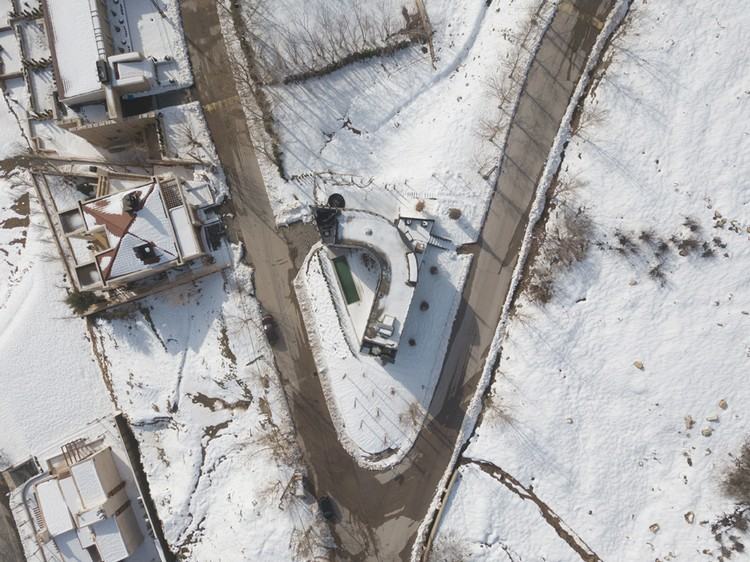 zakrivený dom v zime z vtáčej perspektívy