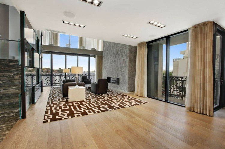 V obývacej izbe s posuvnými sklenenými oknami sú mramorové steny s drevenou podlahou