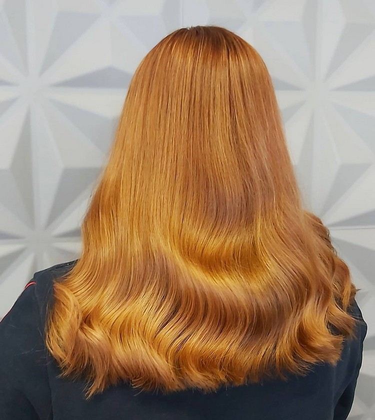Svetlé vlny na medených zlatistých blond vlasoch