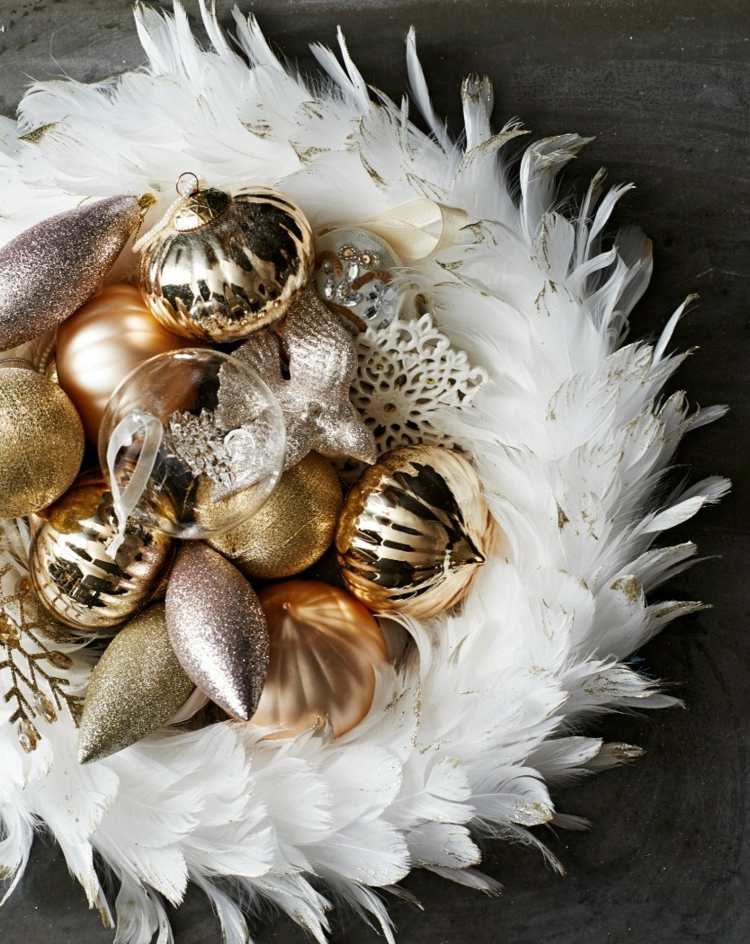 Zlaté ozdoby na vianočný stromček v drotanom hniezde z bieleho peria zlaté vianočné ozdoby vianočné ozdoby vianočné hniezdo biele perie elegantné