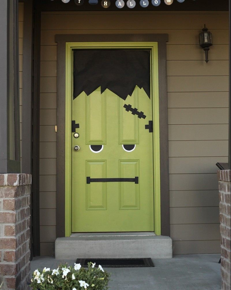 zelené vchodové dvere zdobené ako Frankenstein na Halloween halloween-deco-house-frankenstein-green-door-black-construction-paper