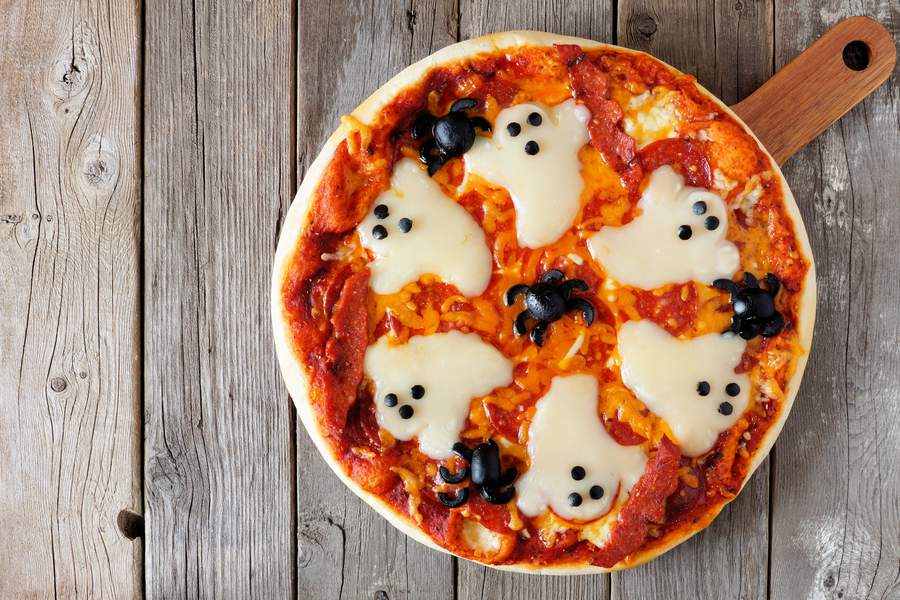 Klasická okrúhla pizza s duchmi a pavúkmi na halloweensku párty