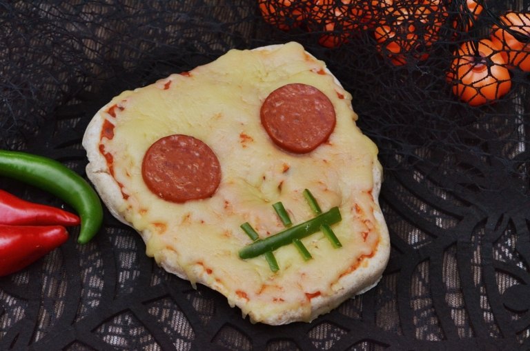 Zábavná halloweenska pizza v tvare lebky so salámou, paprikou a syrom