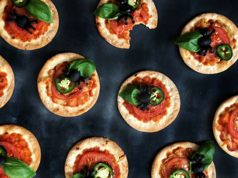 Mini pizze s paradajkami, chilli a pavúkmi vyrobené z olív sú chutné a dekoratívne