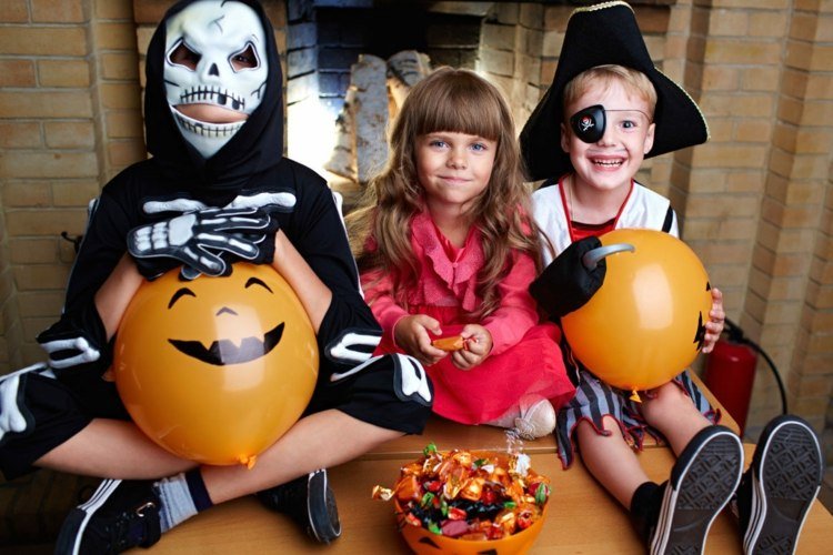 Deti v kostýmoch si užívajú sviatok Halloween a sladkosti halloween hry chlapci dievčatá kostýmy balóny cukríky