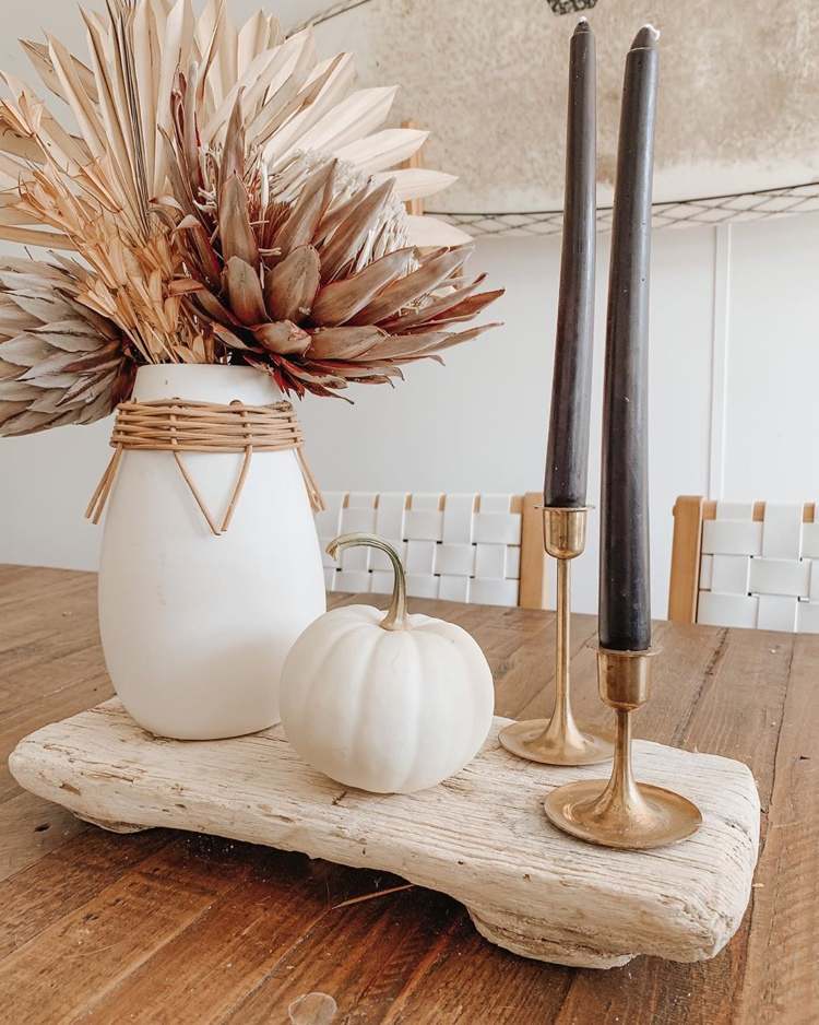 biela tekvica, sušené kvety vo váze a čierne sviečky