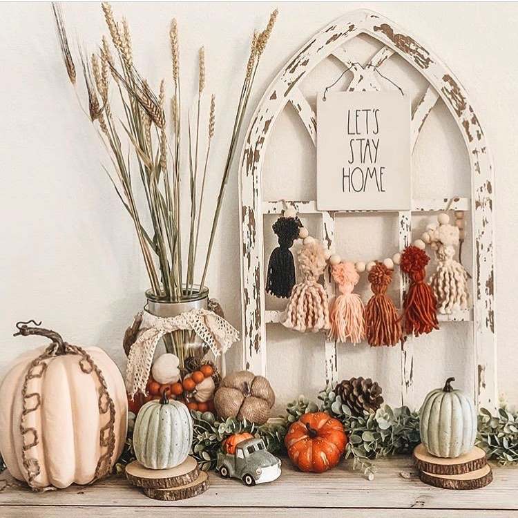 Girlanda z vlnených strapcov a tekvíc naaranžovaných na komode