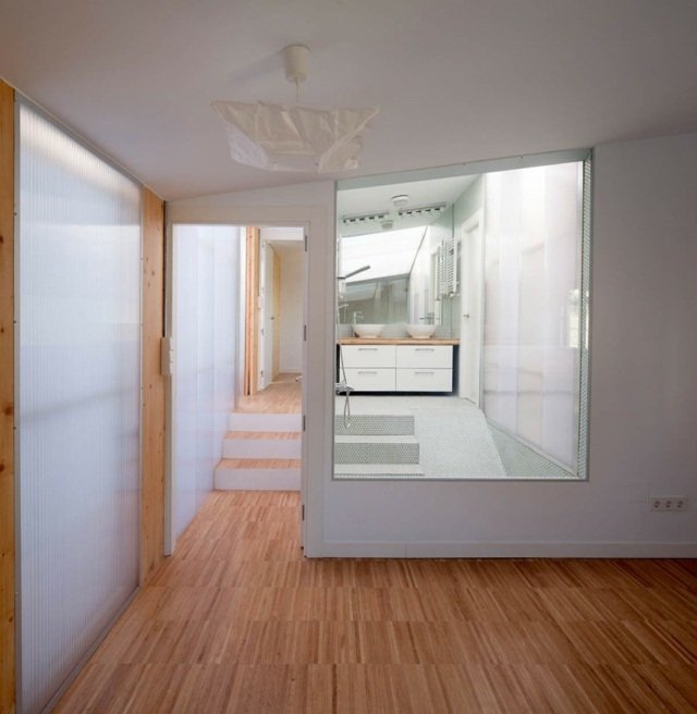 malá kuchyňa obývacia izba biele steny s vysokým leskom laminát Obývacia časť biele steny s vysokým leskom laminátová podlaha