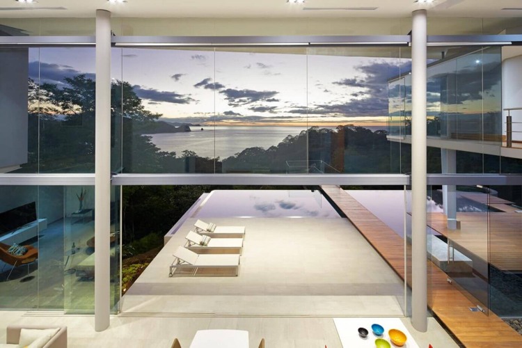 Pohľad na exotickú krajinu cez sklenené steny dom-zo-skla-výhľad na more-otvorená-izba-dizajn-moderný