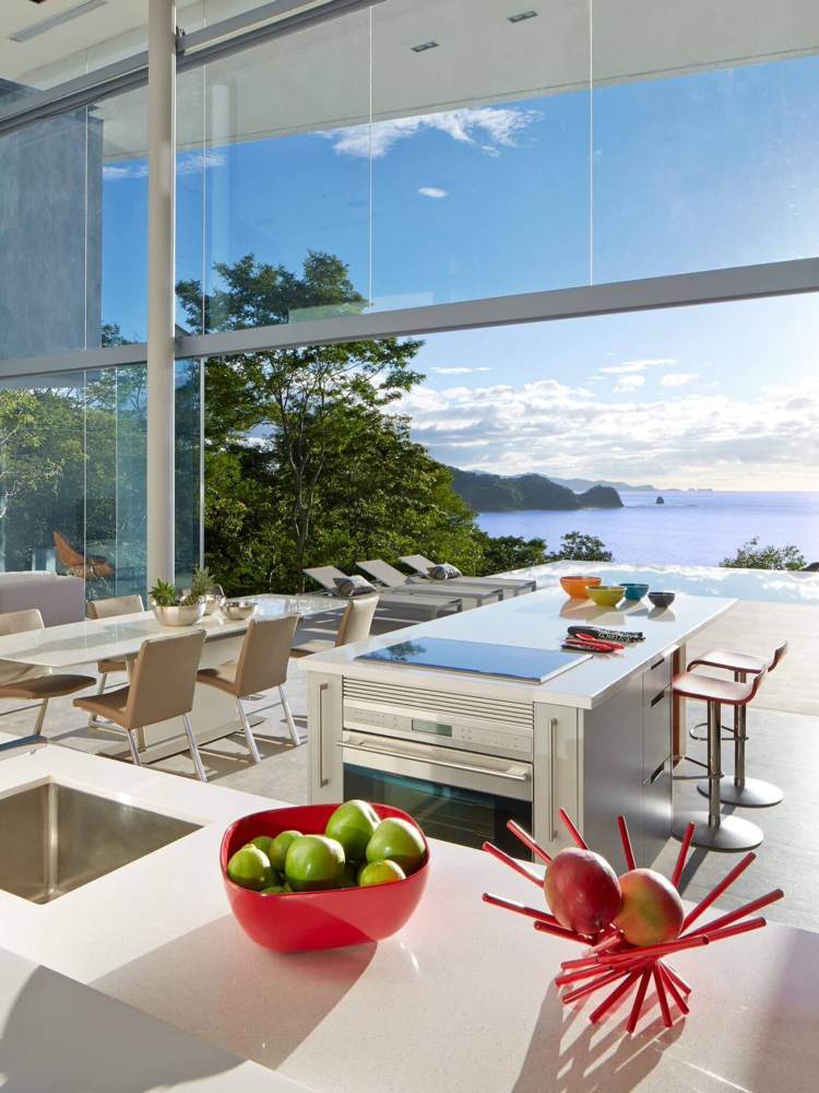 Pohľad na oceán cez sklenené steny od podlahy až k stropu dom-zo-skla-výhľad na more-moderná-kuchyňa-sklenená stena