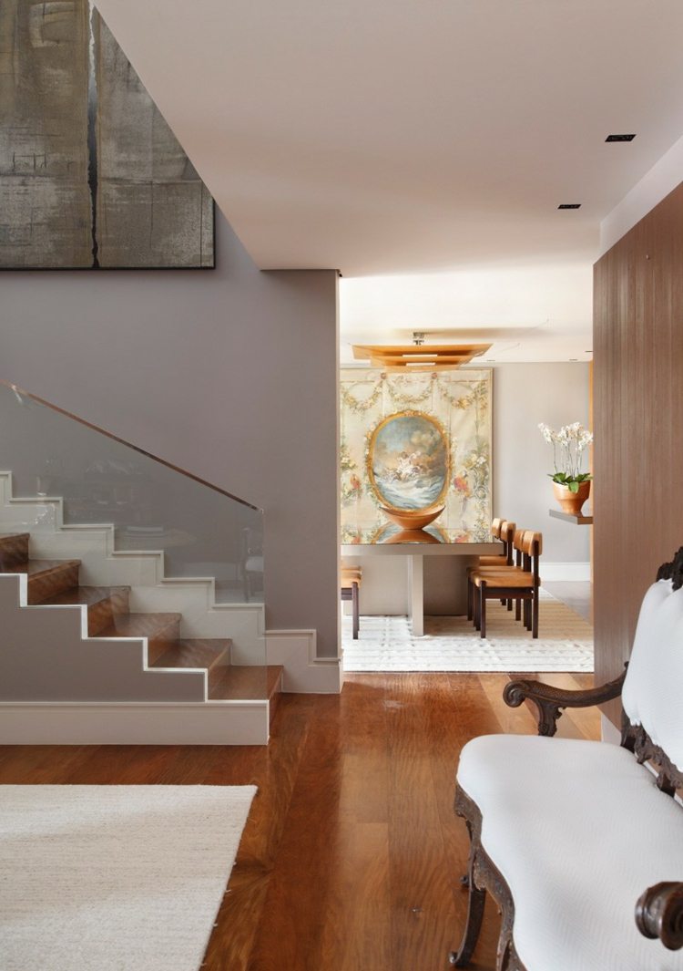 Podlaha z tmavého dreva zdobí obývaciu izbu a schodisko interiér domu v bielej a tmavej drevenej chodbe schody sklenené zábradlie nástenná maľba