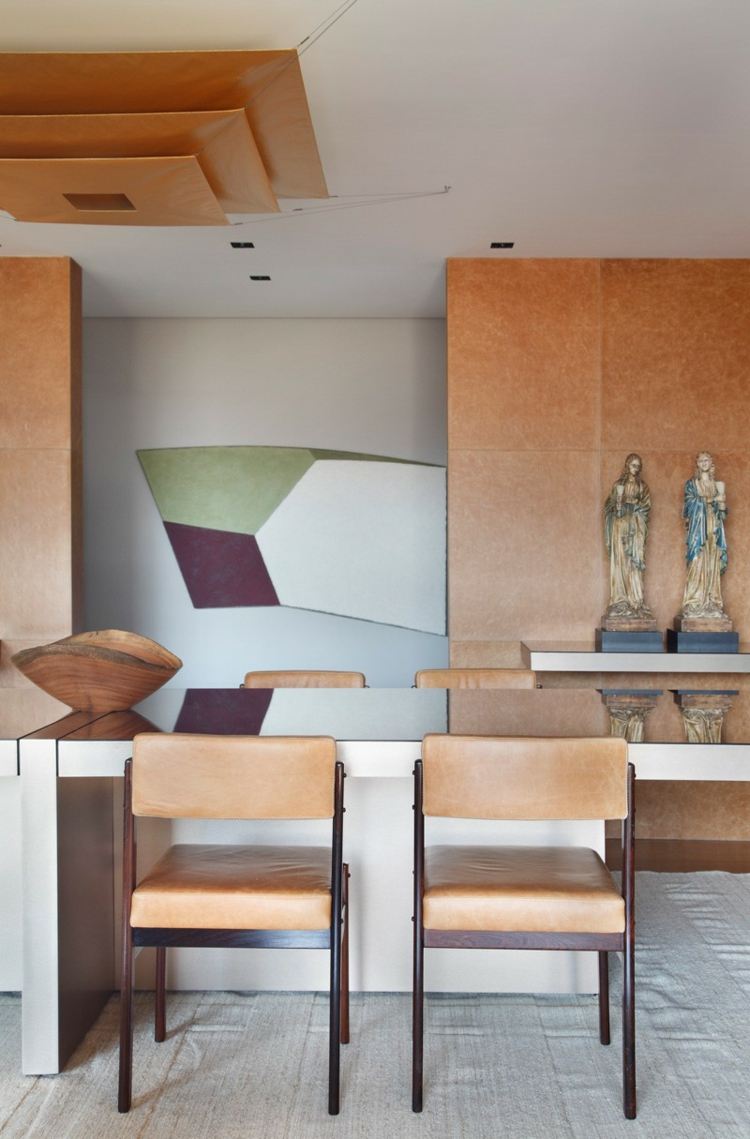 V jedálni domu sú kožené stoličky a dekorácie interiér domu biela tmavá drevo deco nástenná stropná lampa figúrky umenie