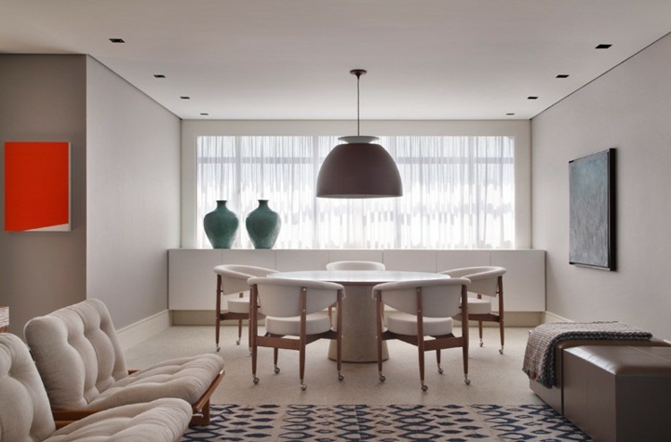 Interiér vyrobený z dreva a s bielymi vankúšmi v salóniku na hornom poschodí interiér domu biely tmavý drevený okrúhly stôl stolík koberec vzor kožená taburetka