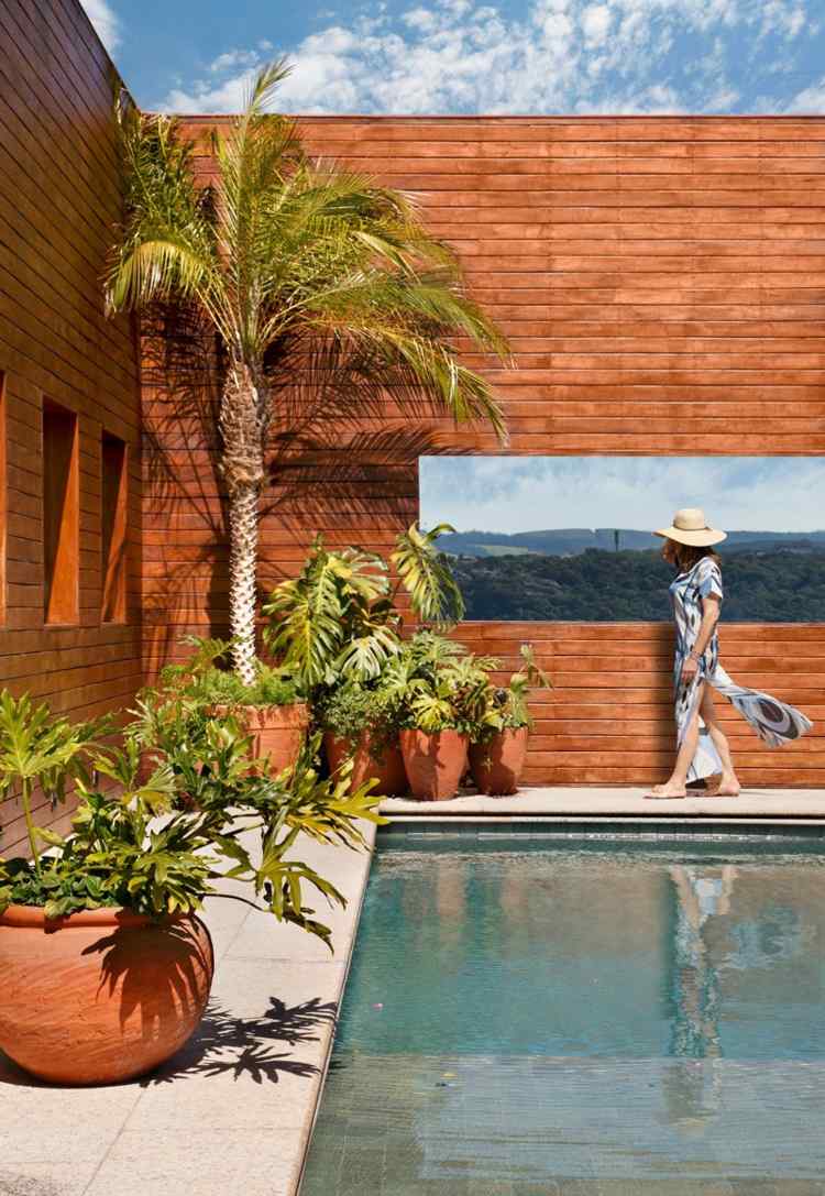 Fasáda domu je taktiež drevená interiér domu biely bazén z tmavého dreva vonkajšia palmová fasáda