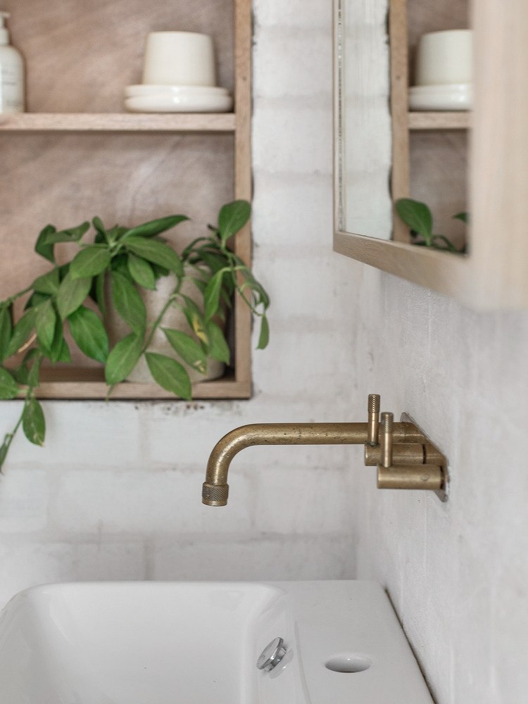 rustikálny medený faucet ako dizajnový prvok v interiéri pred drevenou policou