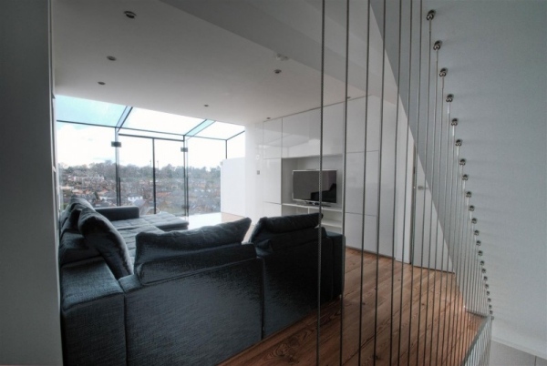 Obývacia izba drevená podlahová krytina schodisko zábradlie čierna sedačka