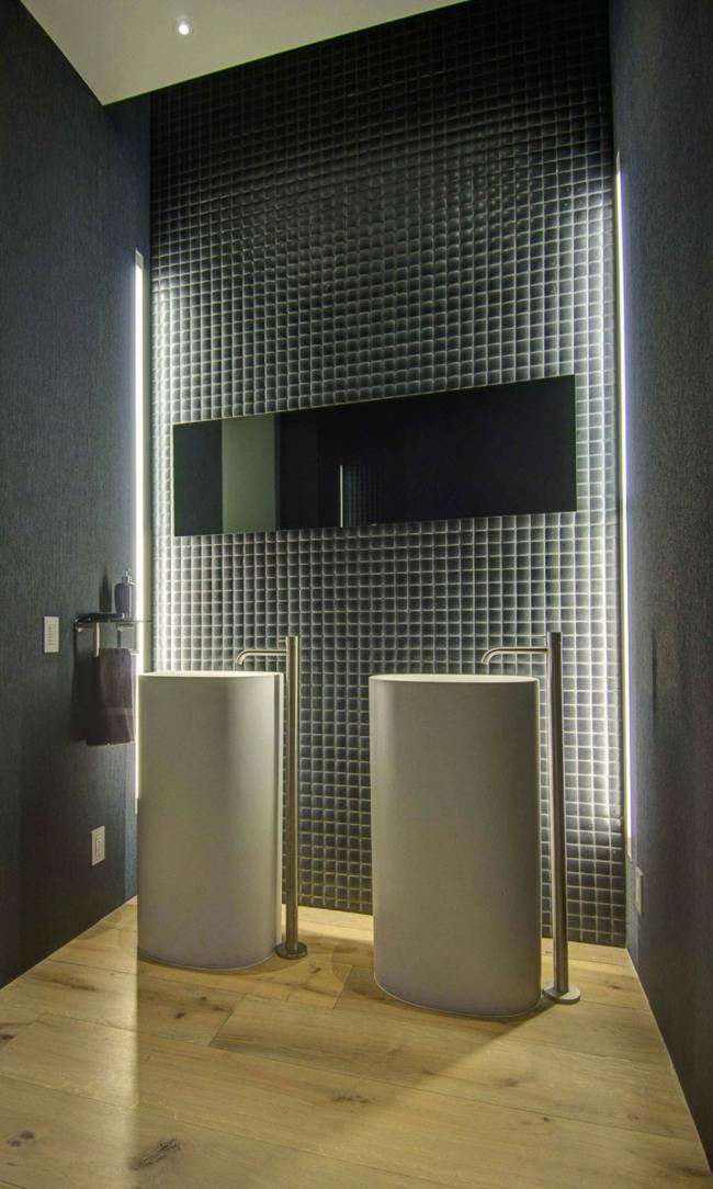 futuristické nástenné osvetlenie do kúpeľne s vysokým drezom tmavé obklady mozaika zapustené vysoké umývadlo nástenné osvetlenie