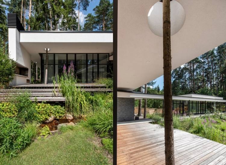 dom so sklenenou prednou terasou pokrytý stromom