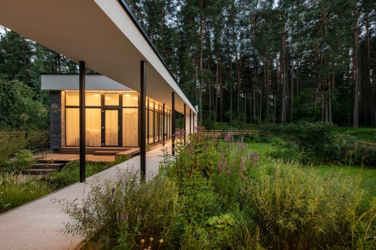 dom so sklom v prednej časti pôvodných rastlín pred domom