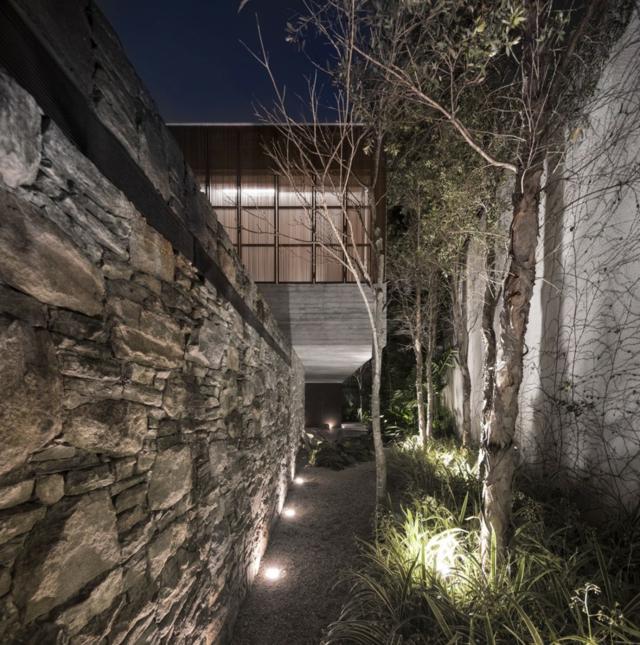 Záhrada s betónovým múrom integrovaným osvetlením stromov integrované osvetlenie stromy záhrada rodinný dom veľké okná fasáda