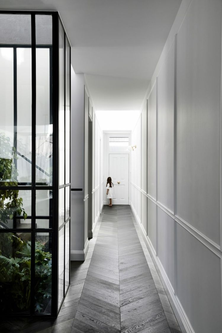 moderné parkety z rybej kosti v sivej farbe na chodbe a bielych stenách