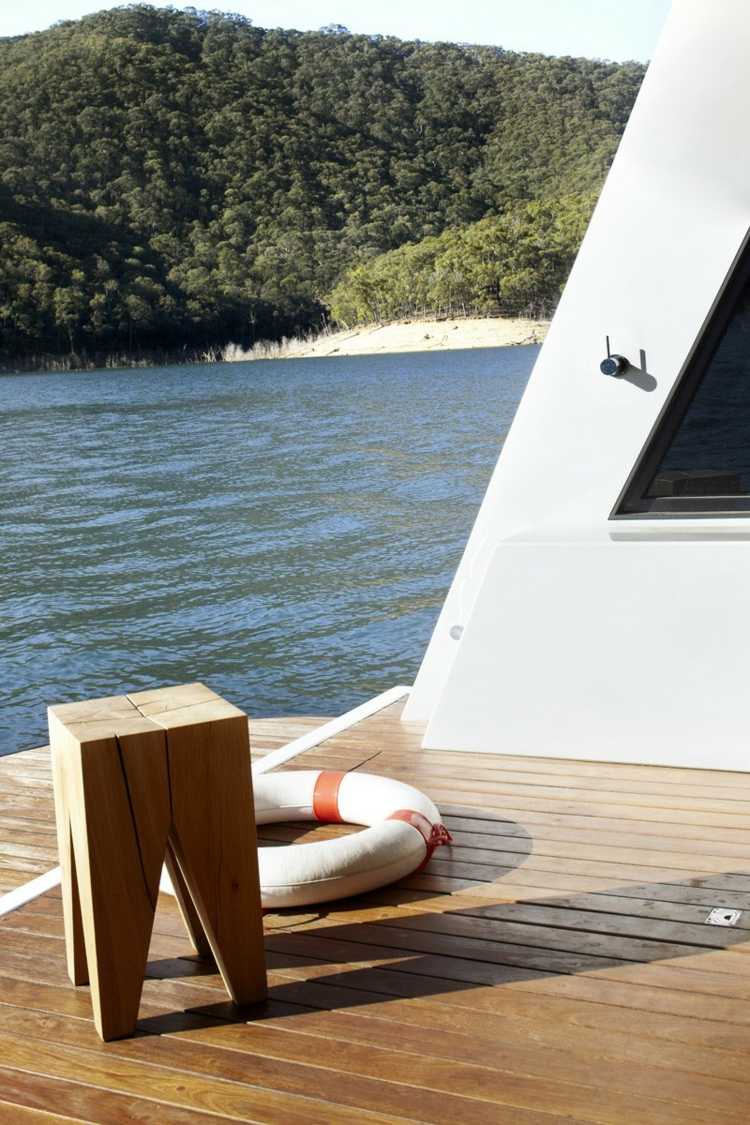 Paluba hausbótu s drevenou podlahou a pôvodnou taburetkou hausbót vnútorné zariadenie drevená podlaha vonkajšia stolička záchranné koleso