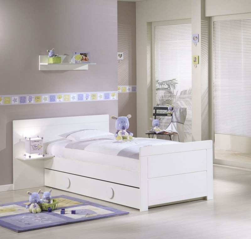 Biela posteľ kombinovaná s fialovými a zelenými ozdobami detská izba biele fialové akcenty rolety koberec plyšové zvieratko