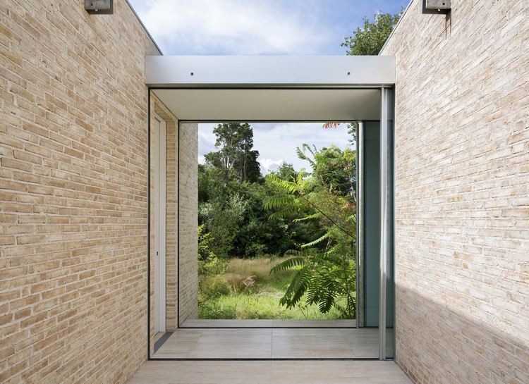 chodba medzi budovami, posuvné sklenené dvere, svetlé klinkerové tehly