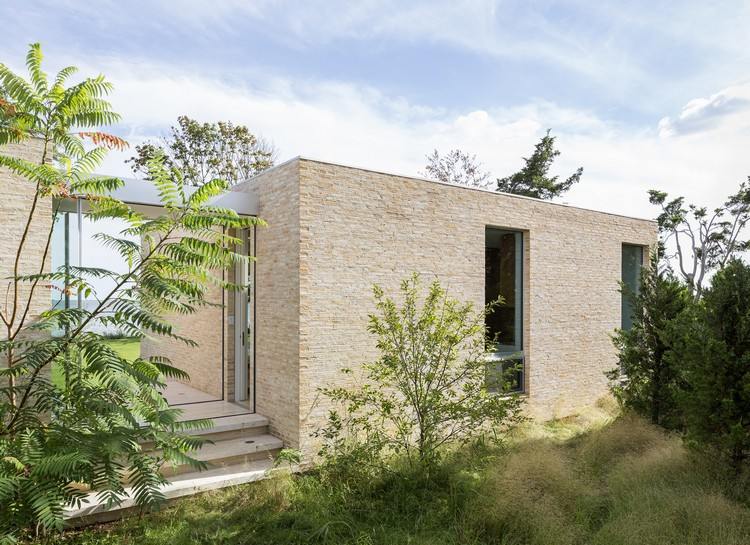 svetlý klinker fasáda plochá strecha dom záhradné rastliny