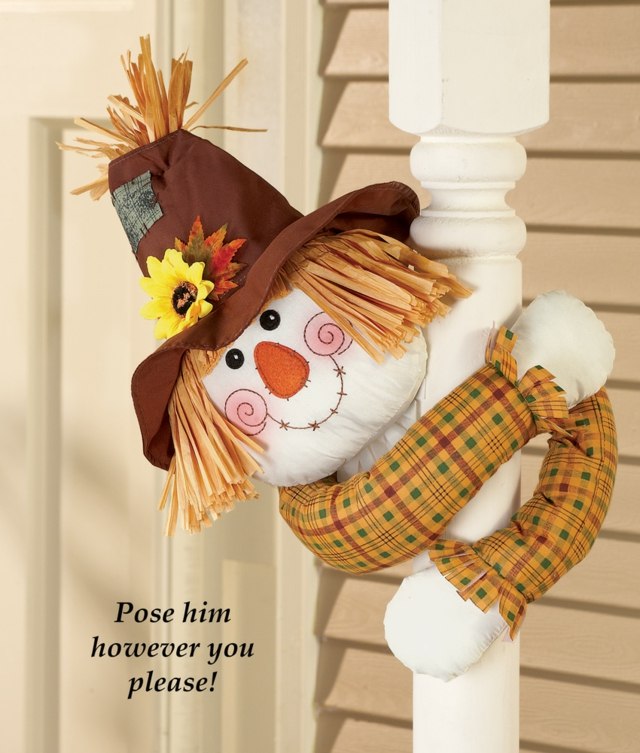 Látková figúrka na drevenom stĺpiku pred domom.Jesenné motívy Látkový muž lezie na nápad na výzdobu dreveného stĺpu pred domom